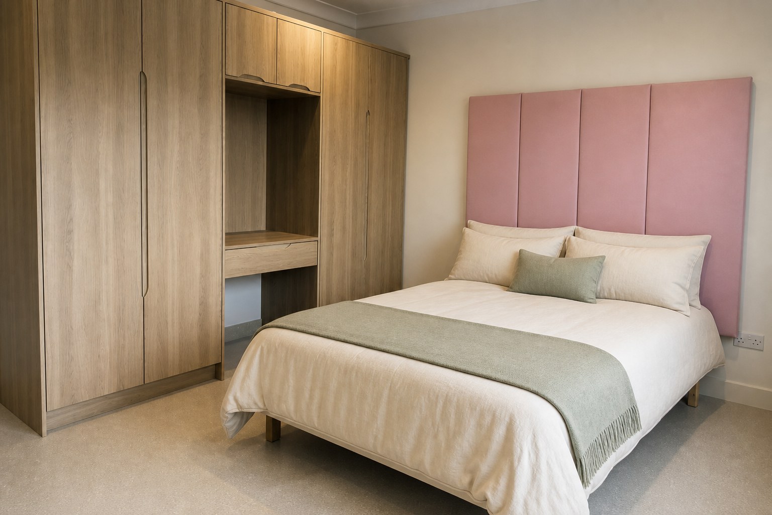 Private bedroom at Heron House with dusty-pink headboard and oak wardrobe